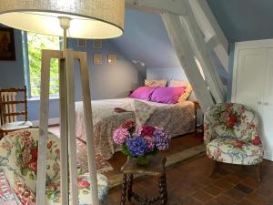 een slaapkamer met een bed en twee stoelen bij maison de charme à 1h 30 de Paris in Saint-Éman