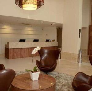 eine Lobby mit Ledersesseln, einem Tisch und einem Wartezimmer in der Unterkunft Linhares Design Hotel in Linhares