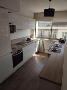 a kitchen with white cabinets and a wooden floor at NICE ÉTOILE in Nice