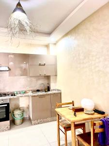 a kitchen with a wooden table and a counter top at Porte de mer Apartement in Essaouira