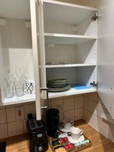 a kitchen cabinet with plates and dishes on the shelf at Premium Studio Flat 05 Near Tower Bridge in London