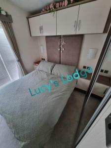 a bedroom with a bed with the words louis lookup at Lucy's Lodge in Rhyl