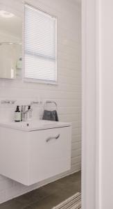 ein weißes Badezimmer mit einem Waschbecken und einem Spiegel in der Unterkunft Brookwood Cottage in Somerset West