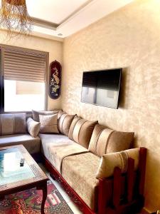 a living room with a couch and a flat screen tv at Porte de mer Apartement in Essaouira +3 photos