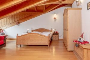a bedroom with a wooden bed in a attic at Residence Stella in Folgaria