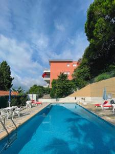 une grande piscine avec des chaises et un bâtiment dans l'établissement Mansfield vue carte Postale Terrasse Piscine calme port à 200m à pied, à Menton