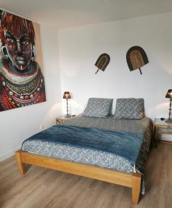 a bedroom with a bed with a painting on the wall at Appartement "La Marine" vue mer in Saint-Pair-sur-Mer
