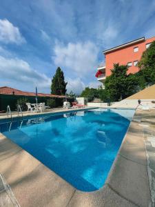 a large blue swimming pool in front of a building at Mansfield vue carte Postale Terrasse Piscine calme port à 200m à pied in Menton