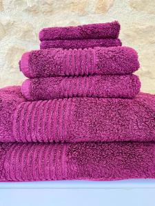 Aulnay的住宿－La Montgrande, 2 bed gîte, Aulnay，墙上的紫色毛巾堆