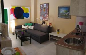 a living room with a couch and a kitchen at Livemalaga San Juan in Málaga