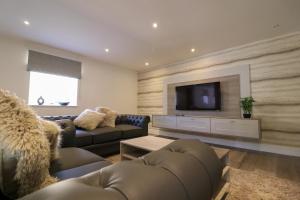 a living room with a couch and a flat screen tv at Northumberland Luxury Stays - The Newland in West Chevington