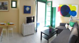 a living room with a couch and a television at Livemalaga San Juan in M&aacute;laga