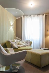 1 dormitorio con 1 cama, 1 silla y 1 ventana en Logis Hôtel Tante Yvonne & son restaurant semi-gastronomique - Lyon Nord en Quincieux