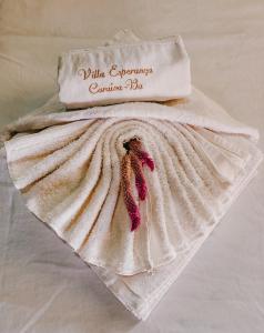 uma toalha em cima de uma cama com uma almofada em Pousada Villa Esperança - Xandó - Caraíva BA em Caraíva