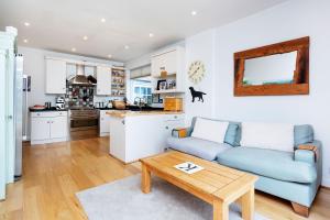 a living room with a blue couch and a table at Veeve - Kew Grass House in Kew