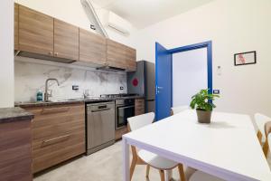 a kitchen with wooden cabinets and a white table at PrimoPiano - K51 in Milan