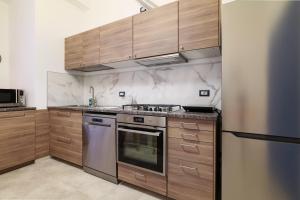 米蘭的住宿－PrimoPiano - K51，厨房配有不锈钢用具和木柜