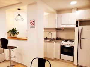 里奧格蘭德的住宿－House Rental RG_Departamento#1，厨房配有白色橱柜、水槽和冰箱。