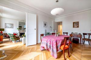 a dining room with a table with a pink table cloth at Veeve - The Hopeful Romantic in Paris