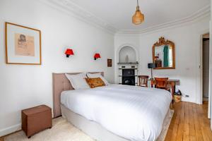 a bedroom with a large white bed and a mirror at Veeve - The Hopeful Romantic in Paris