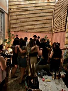 a group of people standing around a table in a room at Baloo Hostel in Athens