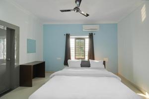 een slaapkamer met een groot wit bed en een raam bij Goroomgo Grace Premium Bhubaneswar in Bhubaneshwar