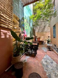 Baloo Hostel في أثينا: فناء به طاولات وكراسي ويوجد لوحة على الحائط