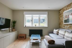 a living room with a couch and a table at Veeve - Pine Reflections in London