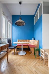 ein Esszimmer mit einem Tisch und einer blauen Wand in der Unterkunft Veeve - A Window to Paris in Paris