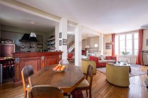 a kitchen and living room with a wooden table at Veeve - Style Bohème in Paris