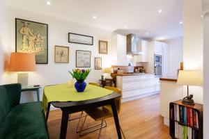 a living room with a table with a vase of flowers on it at Veeve - Explorer's Escape in London