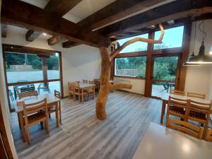 a room with tables and chairs and a tree in the middle at IRATIKO KABIAK in Orbaiceta