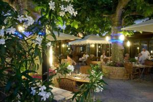 un restaurante con mesas, sillas y flores blancas en Logis Hôtel Tante Yvonne & son restaurant semi-gastronomique - Lyon Nord en Quincieux