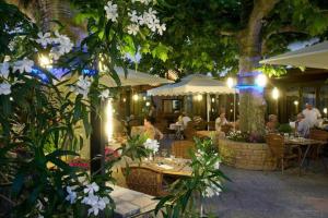 a restaurant with tables and chairs and white flowers at Logis Hôtel Tante Yvonne & son restaurant semi-gastronomique - Lyon Nord in Quincieux