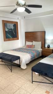 a bedroom with two beds and a ceiling fan at Mansion Serrano Hotel in El Fuerte