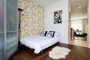 a bedroom with a white bed with a floral wallpaper at Veeve - On Piano Lane in London