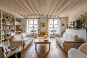 a living room with two couches and a table at Veeve - Loft Living on Luxembourg in Paris