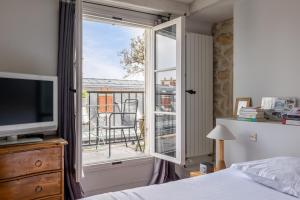 a bedroom with a bed and a window with a balcony at Veeve - Loft Living on Luxembourg in Paris