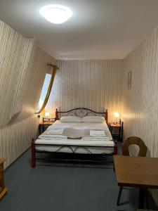 a bedroom with a bed and two chairs and a window at Hotel Schwarzer Adler in Rothenburg ob der Tauber