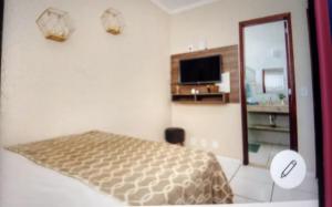 Camera bianca con letto e specchio di Acquamarine Hospedagem Apartamento c 2 quartos e suites para casal ad Arraial do Cabo Altre 5 foto