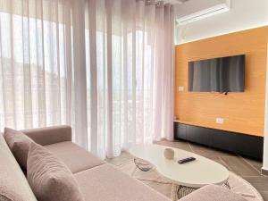 ein Wohnzimmer mit Couch und Fernseher in der Unterkunft LIV Apartments in Vlorë + 7 Fotos