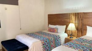 a hotel room with two beds and a lamp at Mansion Serrano Hotel in El Fuerte