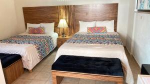 une chambre d'hôtel avec deux lits et une lampe dans l'établissement Mansion Serrano Hotel, à El Fuerte