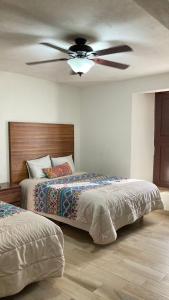 een slaapkamer met 2 bedden en een plafondventilator bij Mansion Serrano Hotel in El Fuerte