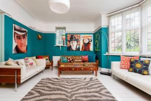 uma sala de estar com paredes azuis e sofás em Veeve - Highgate High Notes em Londres