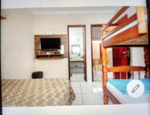 una camera con letto e televisore di Acquamarine Hospedagem Apartamento c 2 quartos e suites para casal ad Arraial do Cabo