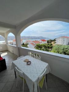 balcón con mesa y vistas al océano en Apartments Edina en Pag