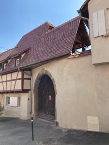 duży budynek z dużymi drewnianymi drzwiami w obiekcie La Grange 1578 w mieście Obernai