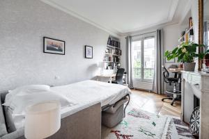a bedroom with a bed and a desk and a window at Veeve - Back to Black in Paris
