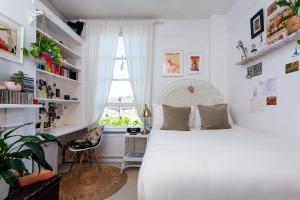a bedroom with a large white bed and a window at Veeve - True Romance in London